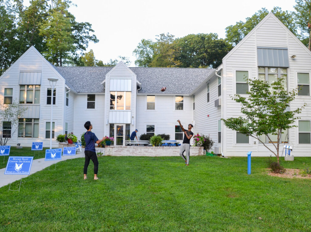 students playing catch in front of school