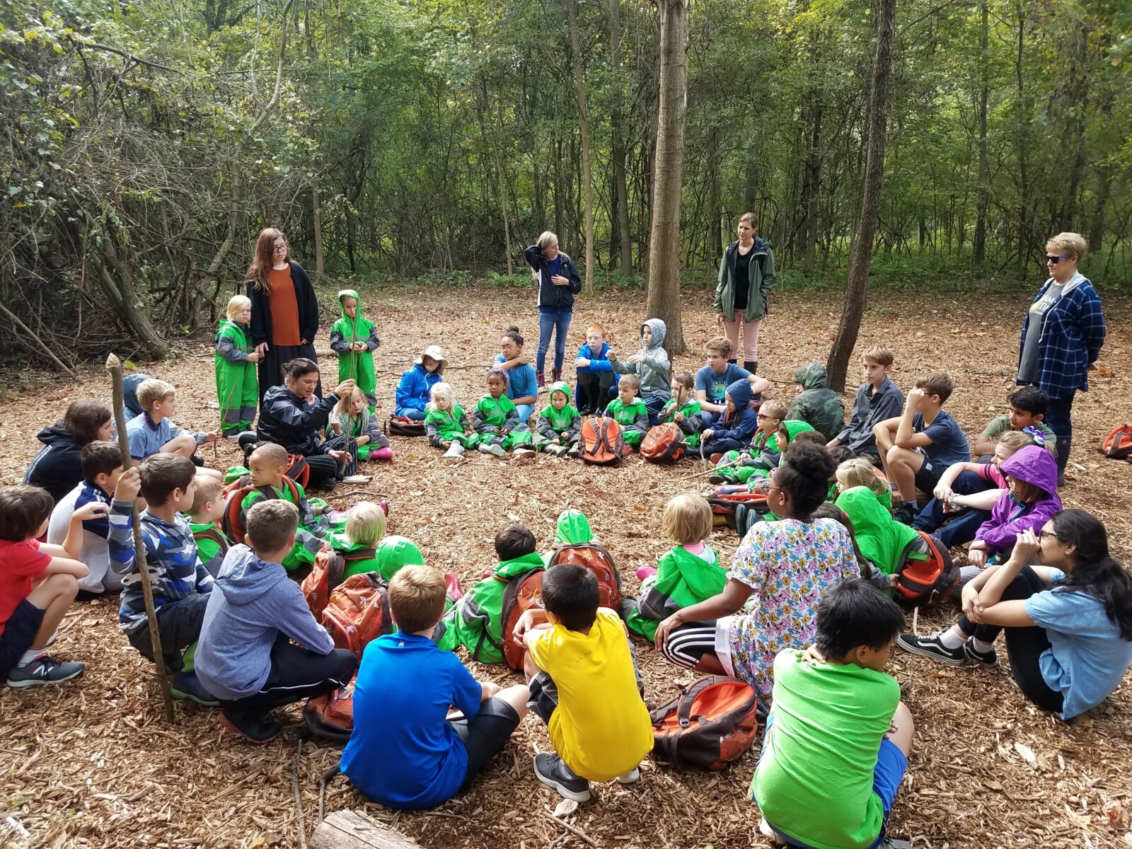 estudiantes sentados en círculo en el bosque