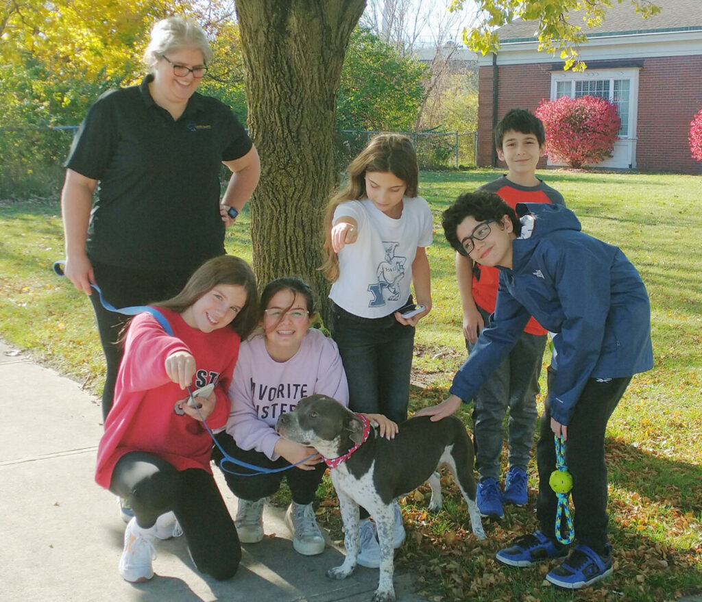 famille avec chien près d'un arbre
