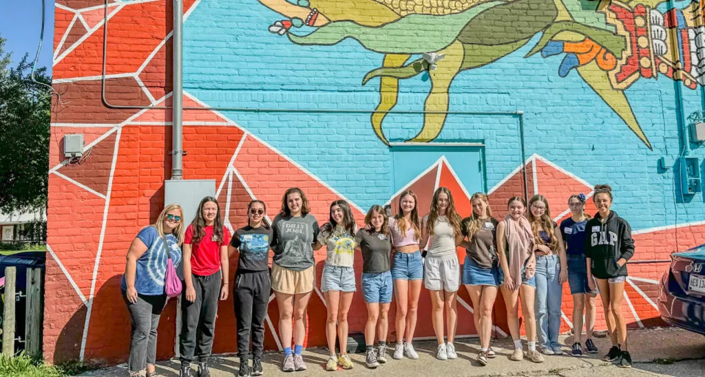 students lined up on colorful wall
